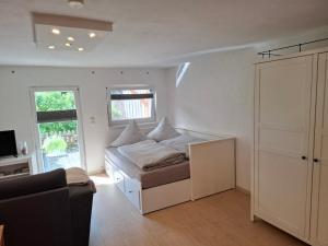 a bedroom with a bed and a couch and a window at Kleine gemütliche Ferienwohnung günstige Lage in Wernigerode