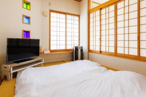 駐車場2台 海中道路や伊計島にアクセス良好 和室付き 最大5名宿泊施設 Guest house mum的电视和/或娱乐中心