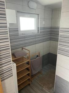 a small bathroom with a shower with a window at Apartma GoDeTi in Rečica ob Savinji +15 photos