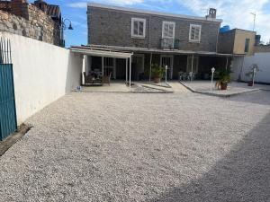 a house with a gravel driveway next to a building at SA DOMU DE S'ORTU in Bari Sardo
