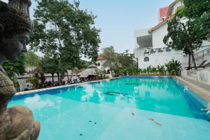 ein großer blauer Swimmingpool vor einem Gebäude in der Unterkunft Padi Heritage Hotel in Karangjepun