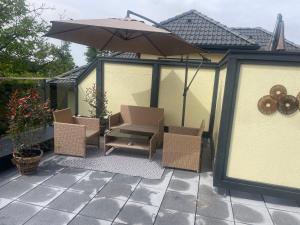 a patio with two chairs and an umbrella at Sorinas Home WB16 Top 7 in Wagersbach
