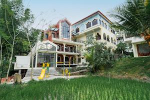 ein großes Haus mit einem Spielplatz davor in der Unterkunft Padi Heritage Hotel in Karangjepun