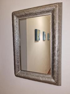 a mirror with a silver frame hanging on a wall at The Yellow House in Portimão +9 photos