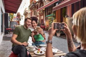 a woman taking a picture of two people sitting at a table at Akka Suites Taksim-Special Class in Istanbul
