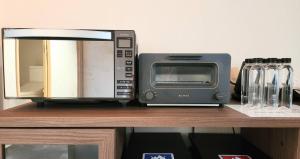 a microwave and a toaster oven on a shelf at LeLien Nakasu in Fukuoka