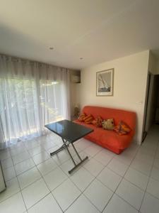 a living room with a red couch and a table at Chalet proche océan in Lège-Cap-Ferret