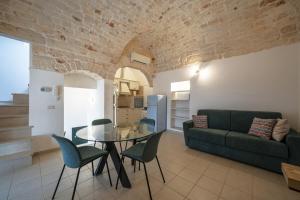 een woonkamer met een glazen tafel en een bank bij Aria di Ceglie authentic elegance in Ceglie Messapica
