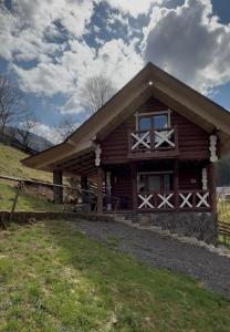 a log cabin with a fence in front of it at Котедж Під лісом in Synevyrsʼka Polyana