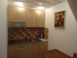 a kitchen with wooden cabinets and a painting on the wall at HOMESTAY ,,Aurora,, in Vilnius