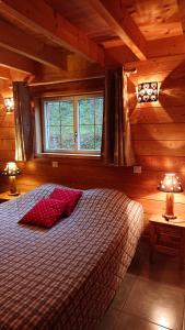 een slaapkamer met een bed in een houten hut bij Au Solé in Basse-sur-le-Rupt