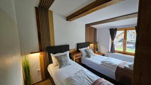 a bedroom with two beds and a window at Hiša stare mame in Kamnik +107 photos