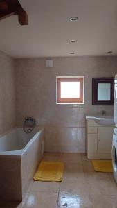 a bathroom with a bath tub and a sink at Atypique maison de charme in Parisot +81 photos