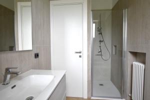 a white bathroom with a sink and a shower at Casa Manu in Brenzone sul Garda +15 photos