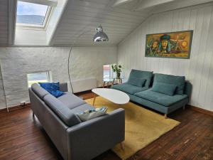 a living room with two blue couches and a table at Sigurd's Loft in Vossevangen