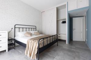 - une chambre avec un lit et un mur en briques blanches dans l'établissement Speakeasy, à Lido di Ostia