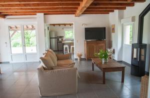 a living room with a couch and a tv at Gîte du Causse Loubressac in Loubressac
