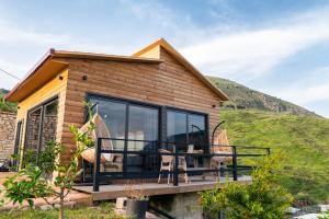 a house with a table and chairs on a deck at Dreamy Farm in Sarandë