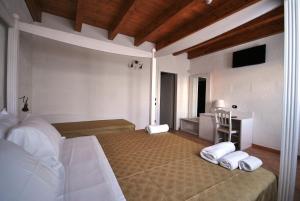 a bedroom with a bed with two pillows and a desk at Agriturismo Tenuta Kyrios con piscina in Borgagne