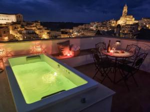 a green bath tub on a balcony with a table at Antica Pepice in Matera