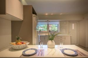 a kitchen with two plates and a bowl of fruit on a table at Alba Boutique Apartments in Laganas