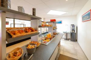 a bakery with croissants and pastries on a counter at Hôtel de la baie de Paimpol in Ploubazlanec