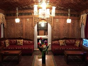 a living room with two couches and a vase of flowers at The Heritage Amina Group Of Houseboats in Srinagar