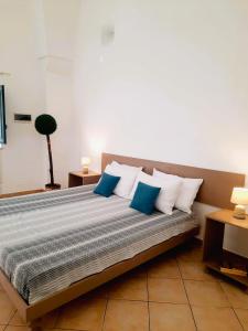 a bedroom with a bed with blue and white pillows at Il Fico d'India - Home Salento com in Ugento