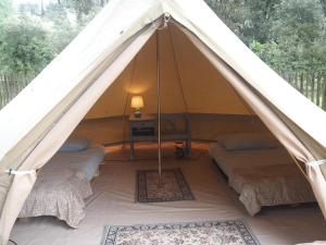 a canvas tent with three beds and a table at Le Spot Saint-Trojan in Saint-Trojan-les-Bains