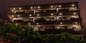 ein Apartmenthaus mit Balkon in der Nacht in der Unterkunft Flisvos Hotel Nafpaktos in Nafpaktos