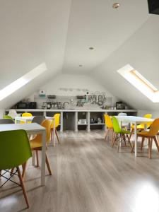 a dining room with white tables and yellow chairs at Być Morze in Mrzeżyno