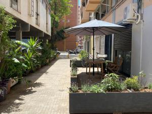a patio with a table and an umbrella on a street at Magnifique appartement près du centre in Barcelona
