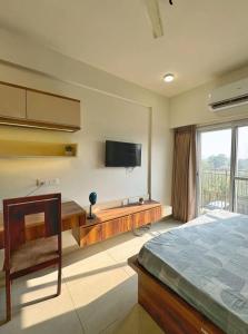 a bedroom with a bed and a tv on the wall at Premium Studio Apartment # 212 Near Bombay Hospital in Siroli