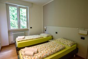 two beds in a room with two windows at Casa Manu in Brenzone sul Garda