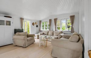 a living room with two couches and a table at Cozy Home In Nykøbing Sj With Wifi in Nakke