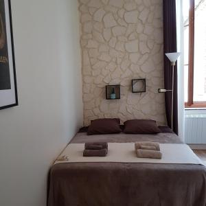 ein Schlafzimmer mit einem Bett und zwei Kissen darauf in der Unterkunft Gîte de la tour avec piscine entre Carcassonne et narbonne in Capendu