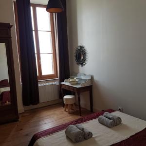 ein Schlafzimmer mit einem Bett, einem Schreibtisch und einem Spiegel in der Unterkunft Gîte de la tour avec piscine entre Carcassonne et narbonne in Capendu