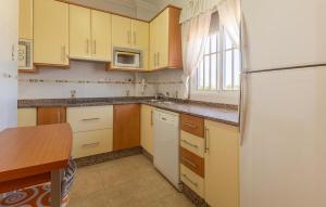 eine Küche mit gelben Schränken und einem weißen Kühlschrank in der Unterkunft Pet Friendly Apartment in San Pedro del Pinatar