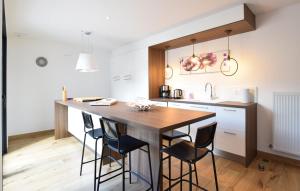 a kitchen with a wooden table and stools at Maison Moderne Proche Plage in Pirou