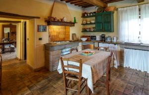 une cuisine avec une table et des chaises et une cuisine avec des armoires vertes dans l'établissement Poggio Lupinaio, à Manciano