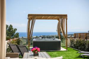 科斯基努Zafora Garden的草坪上设有热水浴缸的花园