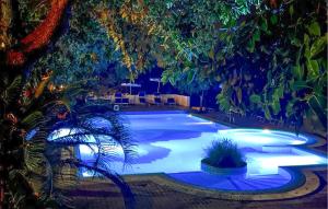 a swimming pool with lights in a resort at night at 1 Bedroom Cozy Apartment In Ricadi in Ricadi +14 photos