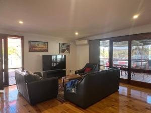 a living room with two leather chairs and a television at Hill Cottage in Clare