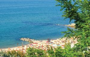 ein Strand mit Sonnenschirmen und Menschen auf dem Wasser in der Unterkunft Nice Apartment In Civitanova Marche in Civitanova Marche