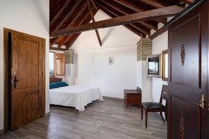 a bedroom with a bed and a wooden door at PUSHE Village Albayzin Art & Culture in Granada