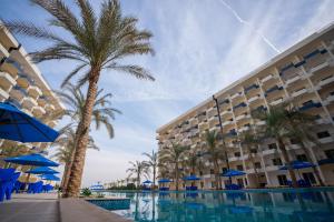 a hotel with a palm tree and a swimming pool at Viva Coast Resort - El Galala - El Sokhna in Ain Sokhna