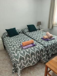 Una cama con dos almohadas encima en una habitación. en Apartamentos Les Palmeres, en Platja d'Aro 81 fotos más