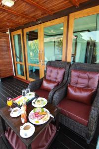 una mesa con dos sillas y una mesa con comida. en Cabana Lipe Beach Resort, en Ko Lipe