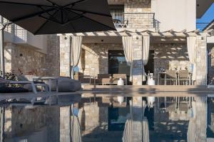 a swimming pool with an umbrella in a house at Olive Residence in Skala Fourkas
