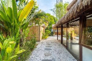 ギリ・アイルにあるVilla Maiyaの植物と建物のある庭園を通る小道
